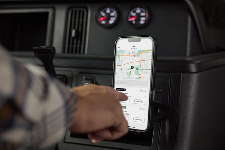 Driver using the My International app on a phone mounted in the cab